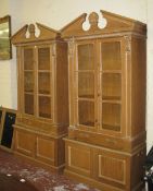 A pair of pine 18th Century style bookcases   each with broken pediment, centred by a shell,