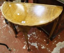 A Georgian style walnut demi-lune side table  , with turned legs and pad feet 74cm wide