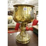 A large cast brass goblet   bearing masks to cup