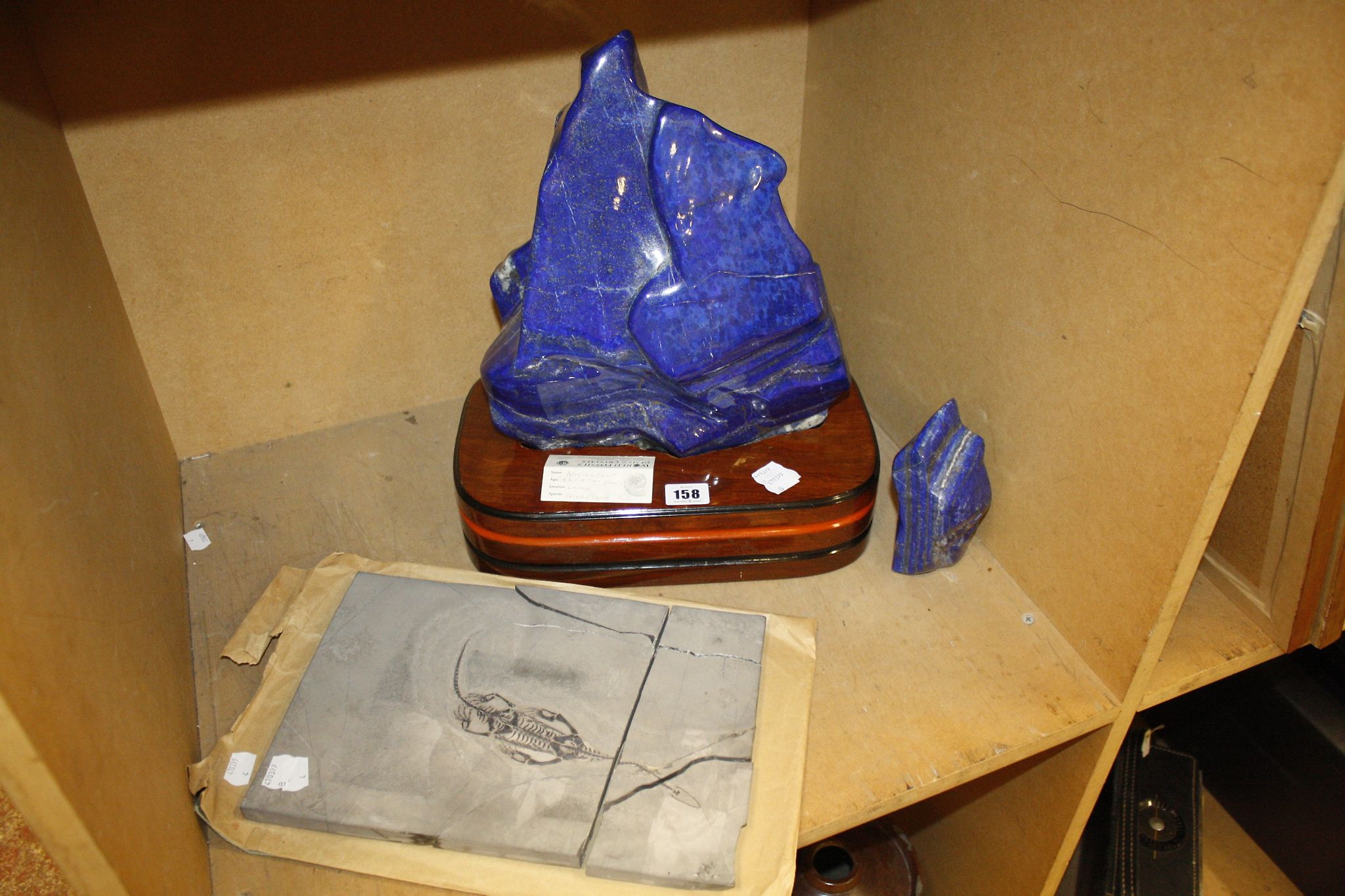 A lapis lazuli specimen on a wooden base,   37cm high, a smaller example and a fossil '