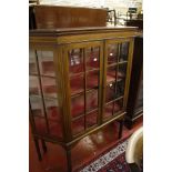 An Edwardian mahogany glazed china cabinet   the pair of doors enclosing two shelves on square legs