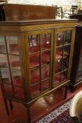 An Edwardian mahogany glazed china cabinet   the pair of doors enclosing two shelves on square legs