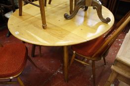 A modern oak circular dining table   with three hoop back chairs