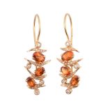 A pair of citrine and diamond earrings,   the oval shaped citrines with diamond accented curved