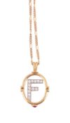 A diamond set pendant on chain,   the diamond set 'F' within an oval surround with a circular