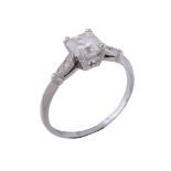 A diamond ring,   the princess cut diamond in a claw setting, between eight cut diamond set