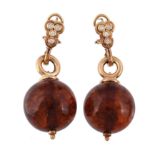 A pair of amber earrings,   the amber orbs suspended from a polished loop, set with brilliant cut