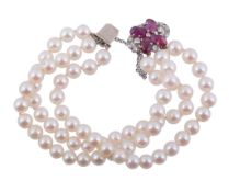 A cultured pearl bracelet with a diamond and ruby clasp  , the three rows of uniform cultured