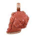 A coral pendant,   carved with the profile of a lady with flowers in her hair, the bale set with a