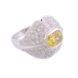 A diamond and yellow diamond dress ring  , the central mixed cut yellow diamond within a pave set