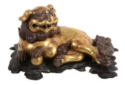 A gilt-metal Buddhistic lion censor and cover, recumbent with one paw on a ball   A gilt-metal