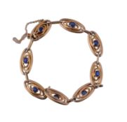 A gold and sapphire bracelet, circa 1910, composed of oval shaped links each...   A gold and