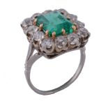 An emerald and diamond ring, the central rectangular cut emerald   An emerald and diamond ring,