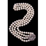 A cultured pearl necklace with a diamond and ruby set clasp, circa 1960   A cultured pearl