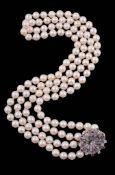 A cultured pearl necklace with a diamond and ruby set clasp, circa 1960   A cultured pearl