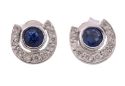 A pair of sapphire and diamond ear studs, the circular cut sapphire within a...   A pair of sapphire