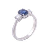 A sapphire and diamond three stone ring, the oval cut sapphire flanked with...   A sapphire and