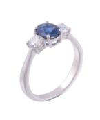 A sapphire and diamond three stone ring, the oval cut sapphire flanked with...   A sapphire and