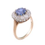 A sapphire and diamond ring, circa 1960, the central circular cut sapphire...   A sapphire and