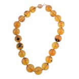 An amber bead necklace, the necklace composed of uniform circular shaped...   An amber bead