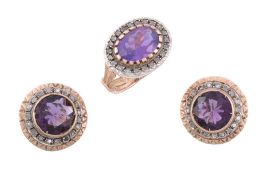 An amethyst and diamond ring, the oval cut amethyst within a surround of...   An amethyst and