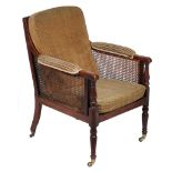 A late George III mahogany framed, caned and upholstered library chair   A late George III