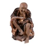 A Chinese stoneware seated figure, with brown glazes and incised details to...   A Chinese stoneware