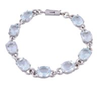 An aquamarine bracelet, the oval cut aquamarines with polished belcher link...   An aquamarine