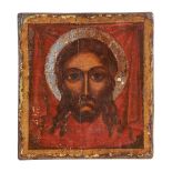 A polychrome painted and parcel silvered icon, the Holy Face, probably Greek   A polychrome