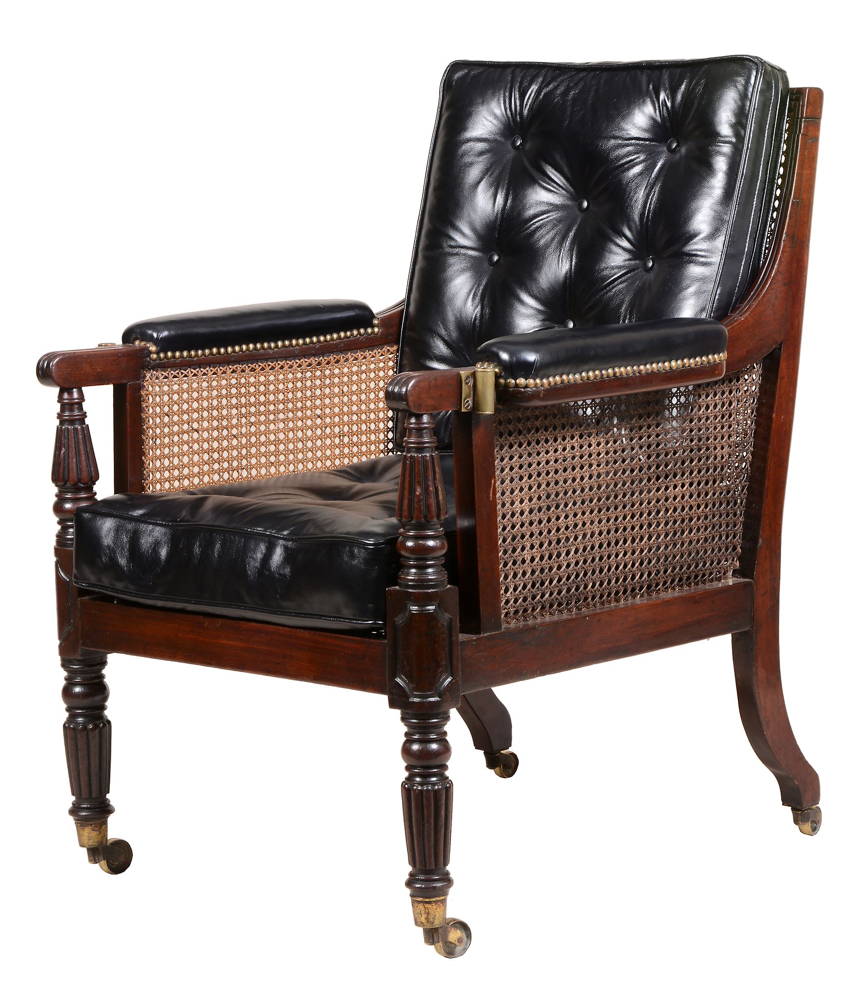 A George IV mahogany library bergere armchair , circa 1825   A George IV mahogany library bergere