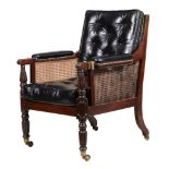 A George IV mahogany library bergere armchair , circa 1825   A George IV mahogany library bergere