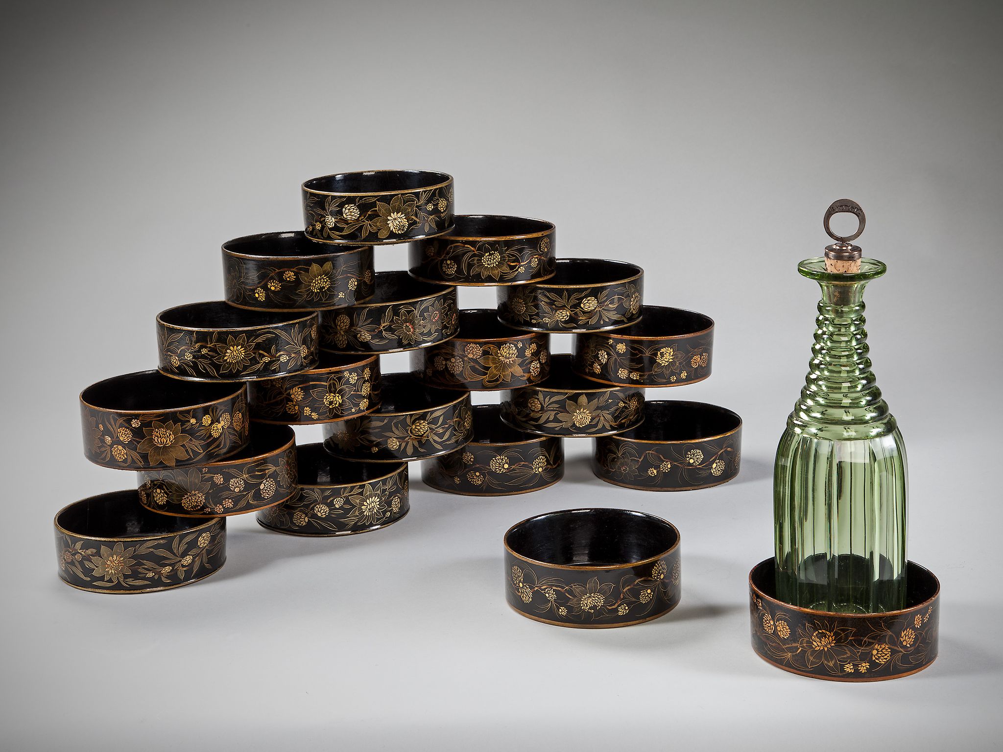 A Set of Eighteen Regency Japanned Papier Mâché Wine Coasters decorated with gilt floral sprays on a