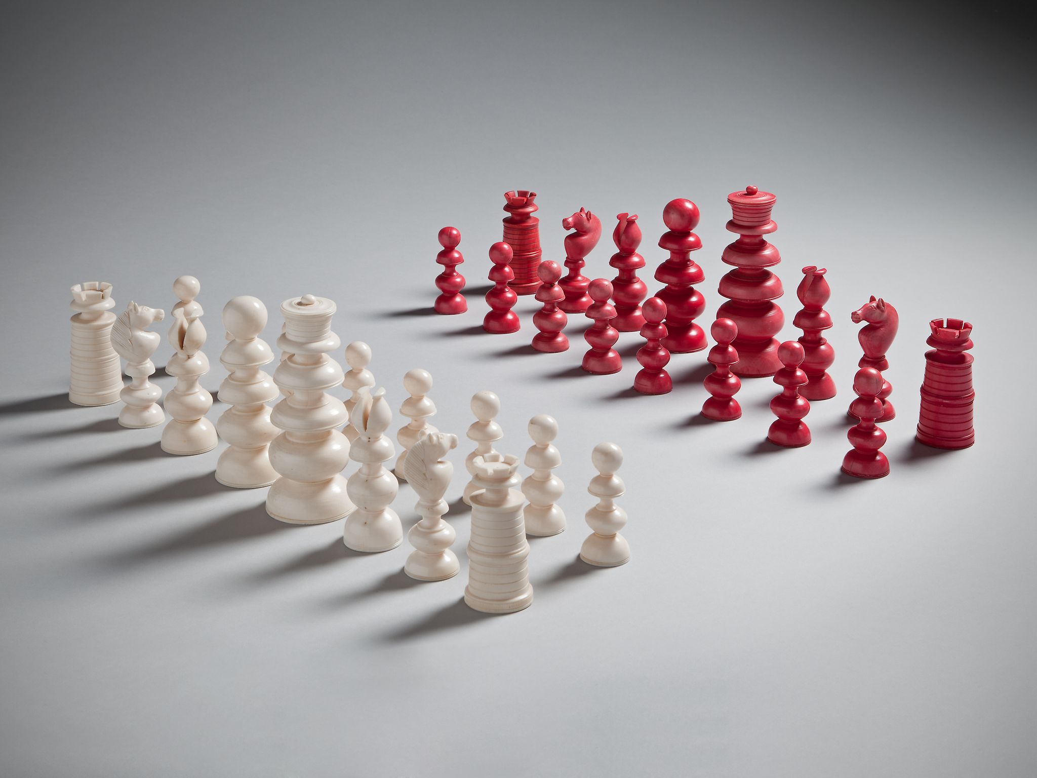 A 19th Century Ivory Chess Set with fine carved details in natural and red-stained ivory 12cm