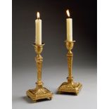 A Pair of 18th Century Russian Ormolu Candlesticks decorated in high relief with neo-classical