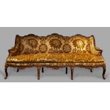 A Louis XV Carved Walnut Settee with an elaborate serpentine frame carved with acanthus, shells