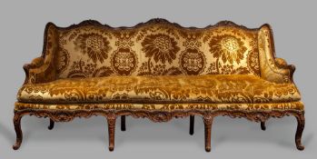 A Louis XV Carved Walnut Settee with an elaborate serpentine frame carved with acanthus, shells