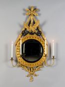 A Pair of Regency Giltwood Convex Girandoles each with a carved bow and ribbon suspending a