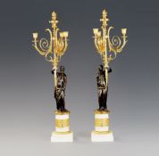 A Pair of French Empire Bronze and Marble Candelabra each with a standing bronze classical maiden