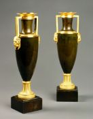 A Pair of French Empire Bronze and Gilt Vases each with a gilt bronze collar and foot, the handles