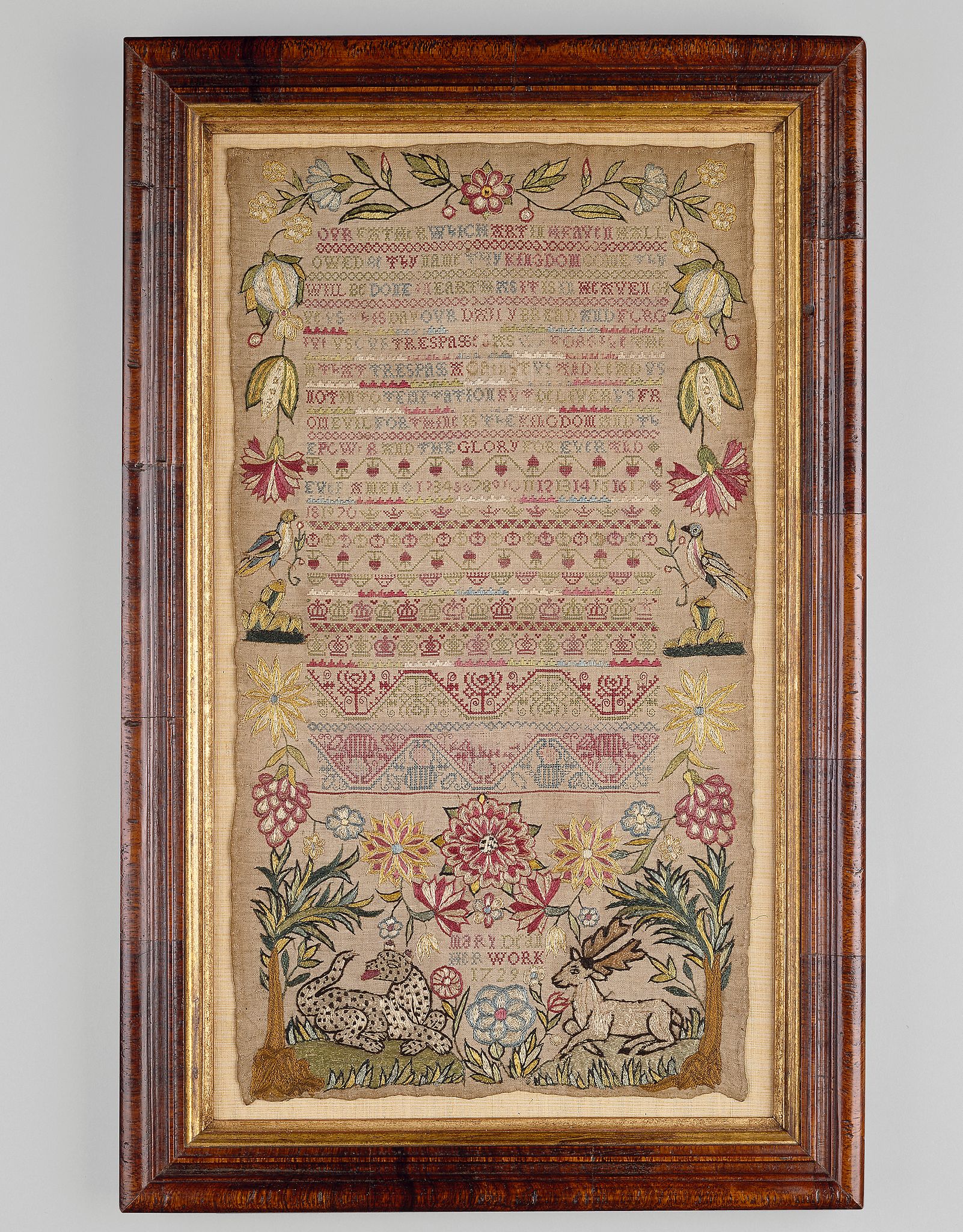 An Early 18th Century Band Sampler worked with the Lord's Prayer, numerals, crowns, honeysuckle