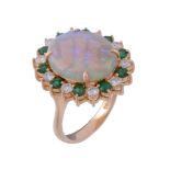 An opal, emerald and diamond ring, the central oval cabochon opal in a four... An opal, emerald