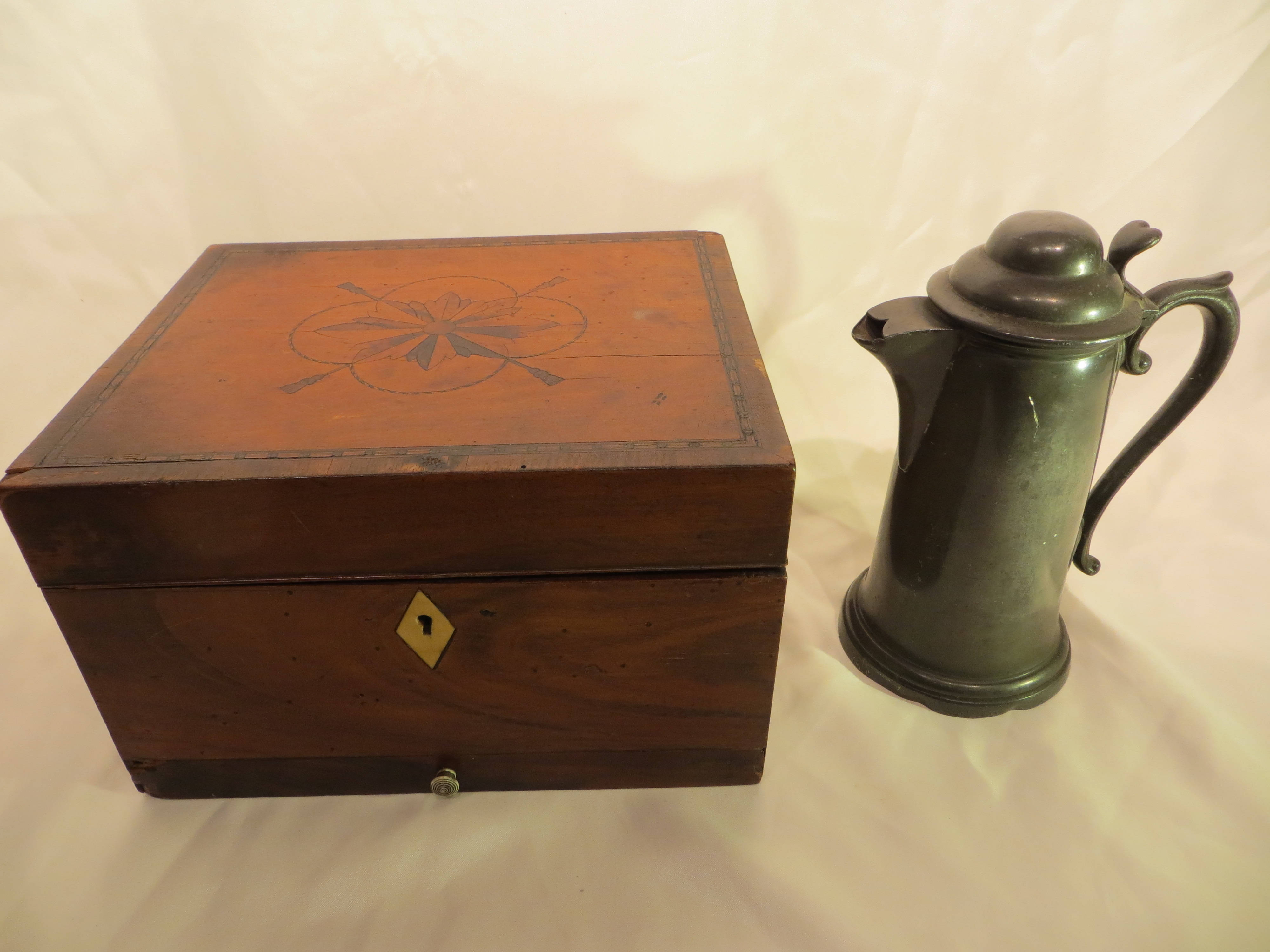 A wooden inlaid box and a pewter jug.