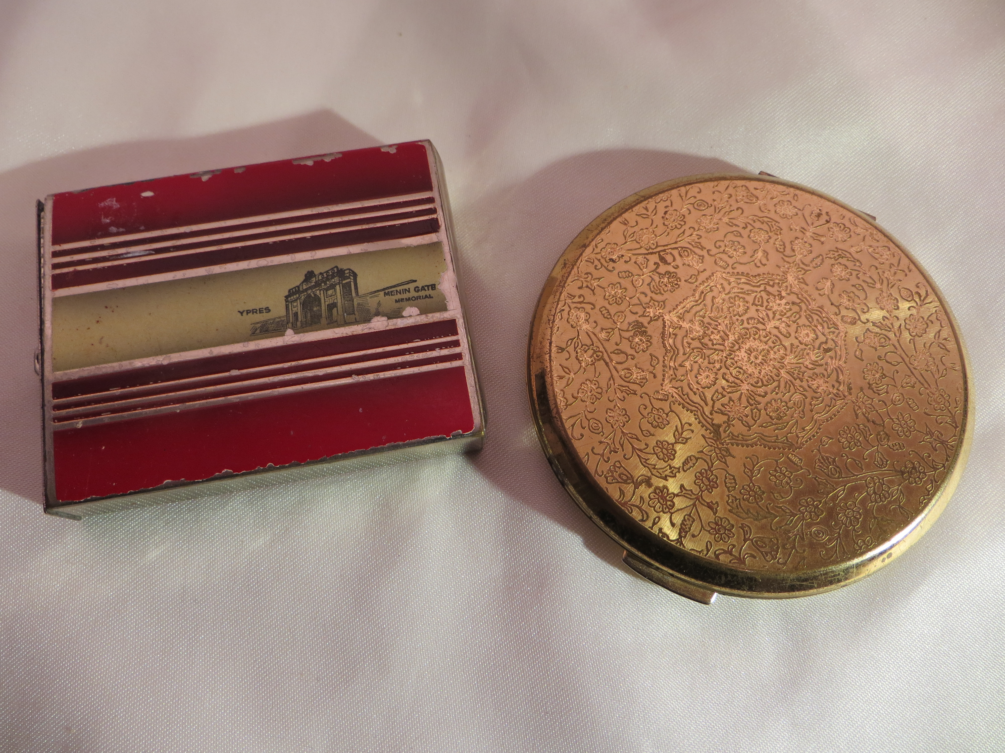 A vintage Stratton compact (mirror a/f), and a push out compact depicting the Ypres Menin Gate.