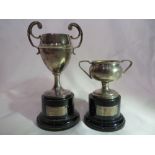 2x Small EPNS trophies on wooden bases which have silver plaques (hallmarked, c.1932).