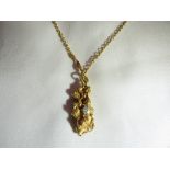 A gold nugget pendant with a solitaire diamond on an 18ct gold chain (tested). Gross weight: 17g