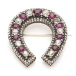 A ruby and diamond brooch of horseshoe design