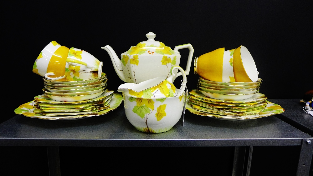 A Grafton china tea set decorated with yellow and green leaves and red berries comprising tea pot,