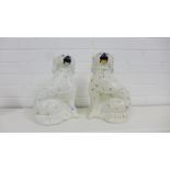 A pair of white glazed Staffordshire chimney spaniels with gilt collars and painted faces (2),