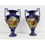 A pair of Staffordshire twin handled pedestal vases with figures to the front against a blue and