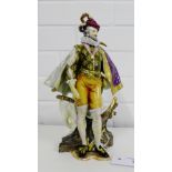 A Berlin porcelain figure of a Gent, modelled standing in purple cape on a shaped base mounted by